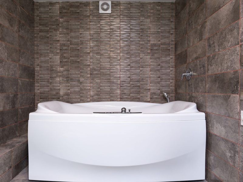 Badezimmer mit dunklen Wand- und Bodenplatten