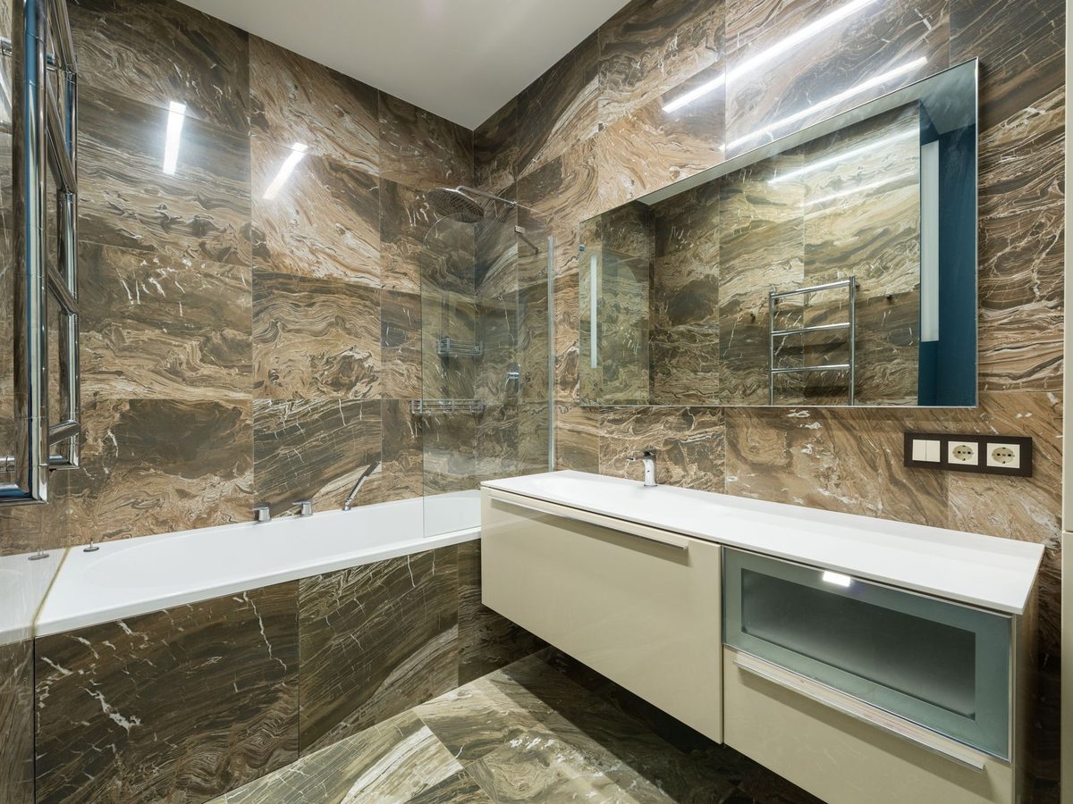 Badezimmer mit dunklen Grossformatplatten an Wand und Boden